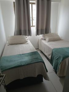 a bedroom with two beds and a window at Alugo QUARTO em Apartamento -Centro de Recife in Recife +6 photos