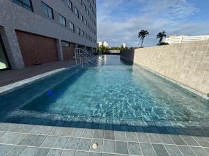 a swimming pool in front of a building at Alugo QUARTO em Apartamento -Centro de Recife in Recife