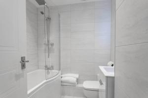a white bathroom with a toilet and a sink at The Huntington - Donnini Apartments in Ayr +8 photos