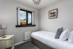 a bedroom with a bed and a window at The Huntington - Donnini Apartments in Ayr