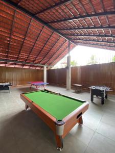 a pool table in a room with two tables at Riveria By Vstays in Kozhikode