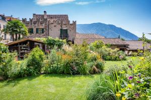 a garden in front of an old castle at Weingut Schmid Oberrautner in Bolzano