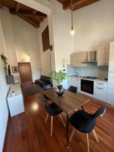 a living room with a table and chairs and a kitchen at Casa Camelia in Zagarolo