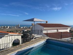 a balcony with a swimming pool and an umbrella at Vista al Mar 2 Peñiscola in Peniscola