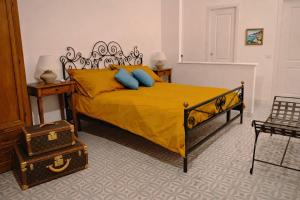a bedroom with a bed with yellow sheets and blue pillows at Campagnano Rural Suite & Spa in Ischia Town +59 photos