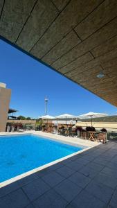 a swimming pool with tables and umbrellas on a building at Terrazas del Gracian in La Puerta