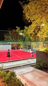 two people playing tennis on a tennis court at night at Terrazas del Gracian in La Puerta