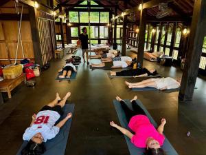 a group of people laying in a gym doing yoga at Dhami Farmstay, Đông Giang, Đà Nẵng in Danang +27 photos