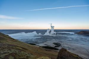 a large body of water with steam in the sky at Northern Light Inn in Grindavík