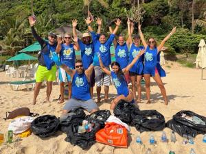 a group of people in blue shirts on the beach at Pipa Roots Hostel in Pipa +20 photos