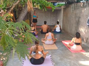 a group of people sitting in a yoga class at Pipa Roots Hostel in Pipa