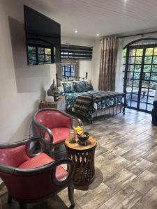 a bedroom with a bed and two chairs and a table at hippomoon lodge game reserve in Hoedspruit