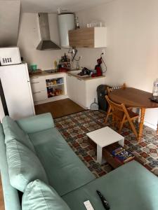 a living room with a green couch and a table at Charmant appartement entre mer et vignes in Portel-des-Corbières