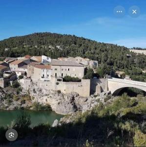 a town on a hill with a bridge over a river at Charmant appartement entre mer et vignes in Portel-des-Corbières