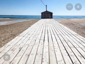 a boardwalk on the beach with a small shack at Charmant appartement entre mer et vignes in Portel-des-Corbières