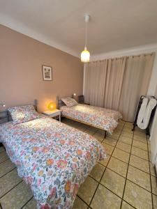 a bedroom with two beds and a lamp at Maison Valras Plage très bon emplacement in Valras-Plage