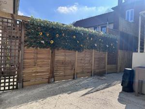 a wooden fence with a bunch of sunflowers on it at le relais des étangs B in Mareuil-Caubert