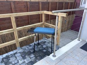 a blue stool sitting in front of a wooden fence at le relais des étangs B in Mareuil-Caubert
