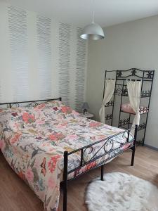 a bedroom with a bed with a floral bedspread at CHEZ NOUS BIS in Commercy