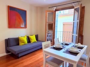 a living room with a table and a couch at Smartmonki Sinagoga entre la Catedral y Zocodover in Toledo