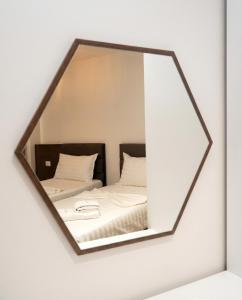 a mirror reflecting a bed in a bedroom at The Honeycomb Boutique Hotel in Golem +70 photos