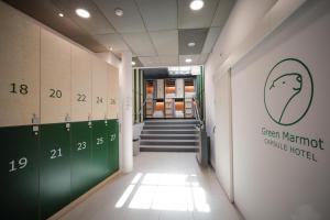 a hallway with a green martiniole hotel sign on the wall at Green Marmot Capsule Hotel Genève - Self check-in in Geneva +23 photos