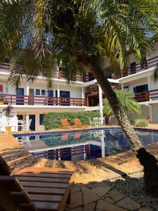 a hotel with a swimming pool and a palm tree at Pousada Dona Emilia in Brotas +33 photos