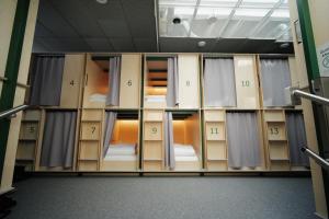 a room full of bunk beds with open doors at Green Marmot Capsule Hotel Genève - Self check-in in Geneva