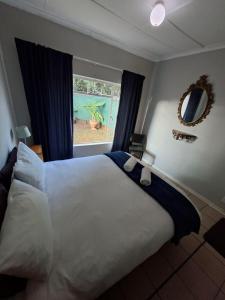 a bedroom with a large white bed and a window at Lullaby Leaf in Lichtenburg +2 photos