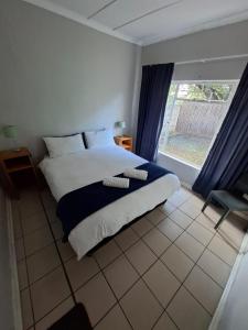 a bedroom with a large bed and a window at Lullaby Leaf in Lichtenburg