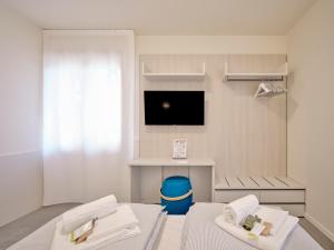 a room with two beds and a tv in it at Pegaso Civico2 in Garda
