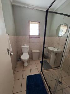 a bathroom with a toilet and a sink at Lullaby Leaf in Lichtenburg