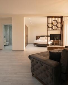 a living room with a couch and a bed at The Honeycomb Boutique Hotel in Golem