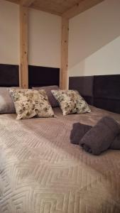 a large bed with two pillows on top of it at Slow Lake House Koszarka in Gródek Nad Dunajcem