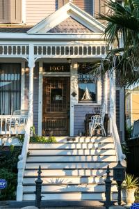 a white house with stairs in front of it at Saint Helens House-Hotel Historic District Near Cruise Port in Galveston