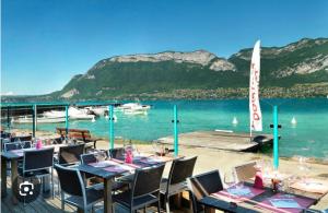 a restaurant with tables and chairs on the water at Calm Waters in Doussard