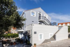 a white house with a white wall at Bacan Serviced Apartments in Cavtat