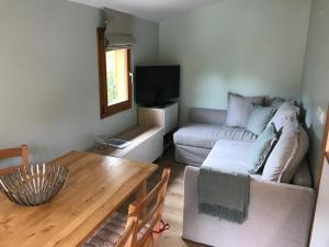 a living room with a couch and a table at Calm Waters in Doussard