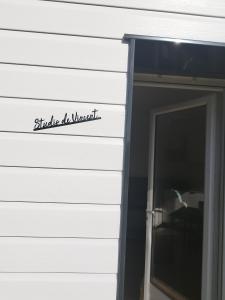 a sign on the side of a building with a door at Studio de Vincent in Bordeaux-Saint-Clair