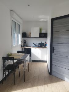 a room with a table and a kitchen with a door at Studio de Vincent in Bordeaux-Saint-Clair +11 photos