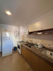 a kitchen with a white refrigerator and a sink at SIERRAS TRAVEL 2f in Villa Carlos Paz