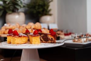 a plate with a piece of cake with strawberries on it at Urban Boutique Hotel Center in Ljubljana +41 photos