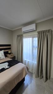 a bedroom with a bed and a window at Waverley Rest in Bloemfontein