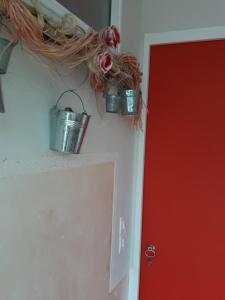 two buckets on a wall next to a red door at Chambres Dubuisson de Bray in Bray