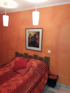 a bedroom with a bed and a painting on the wall at Chambres Dubuisson de Bray in Bray