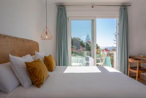 a bedroom with a large bed and a large window at Hotel Fortuna in Los Caños de Meca