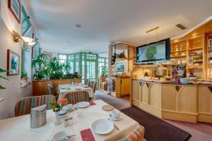 a dining room with a table and a kitchen at Hotel zum Kater in Rostock +6 photos