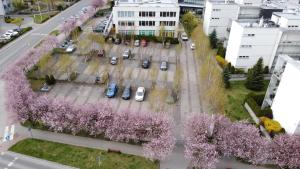 an aerial view of a street with trees with pink flowers at Apartament Bażantowo typu studio z parkingiem in Katowice