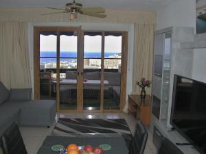 a living room with a couch and a television at Apartmán Vlasta in Arona +4 photos