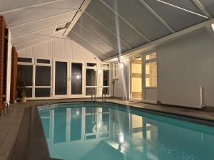 an indoor swimming pool with a roof at Broadway Pool House with Sauna & Jacuzzi in Herne Bay
